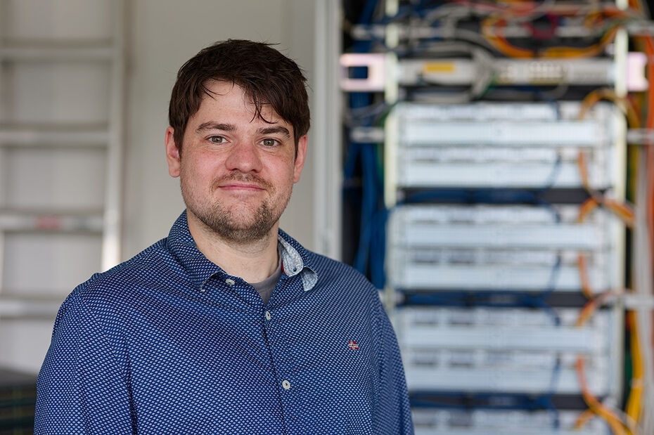 Lächelnder Mann mit braunen Haaren im blauen Hemd